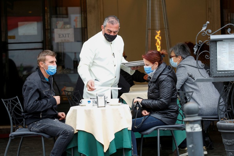 Image: People enjoy their time at a bar on the final day of open restaurants and bars before tighter Covid-19 restrictions are enforced, in Rome, Italy