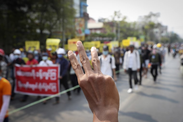 Image: Anti-cup protesters gesture with a three-fingers salute, a symbol of resistance, as they protest against the military coup in Mandalay, Myanmar