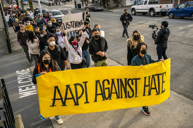 Image: Demonstrators march through the Chinatown-International District during a "We Are Not Silent" rally and march against anti-Asian hate and bias on March 13, 2021 in Seattle.