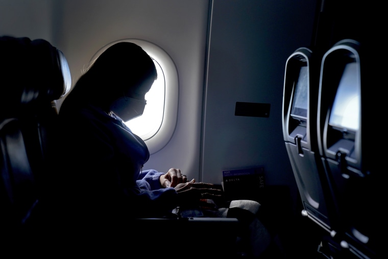 A passenger wears a face mask she travels on a Delta Airlines flight on Feb. 3, 2021, after taking off from Hartsfield-Jackson International Airport in Atlanta.