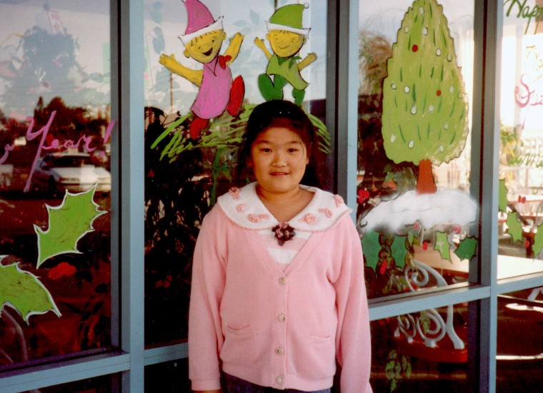 Michelle Yang standing in front of her family's takeout restaurant in Phoenix, around age 11.