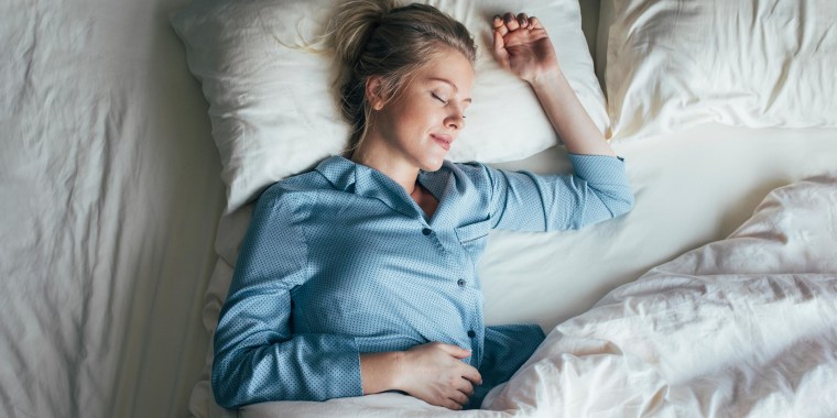 Woman fast asleep in her bed, wearing blue pajama's