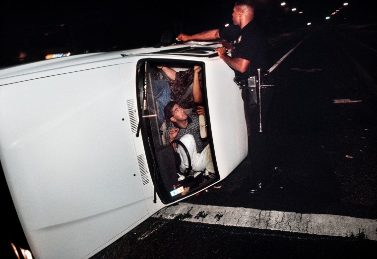 Pacific Division Officer Hoskins tries to pry open the door of a truck involved in an accident that left the driver and passenger locked in the overturned vehicle.