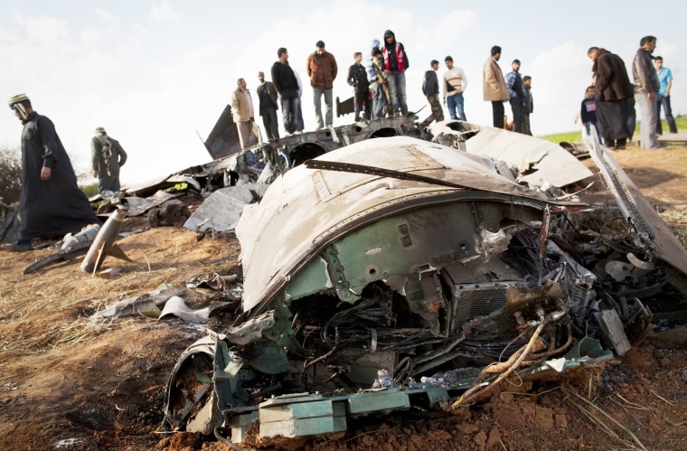 Libyans inspect the wreckage of a US F15 fighter jet after it crashed in an open field in the Libyan village of Bu Mariem, east of Benghazi, on March 22, 2011.