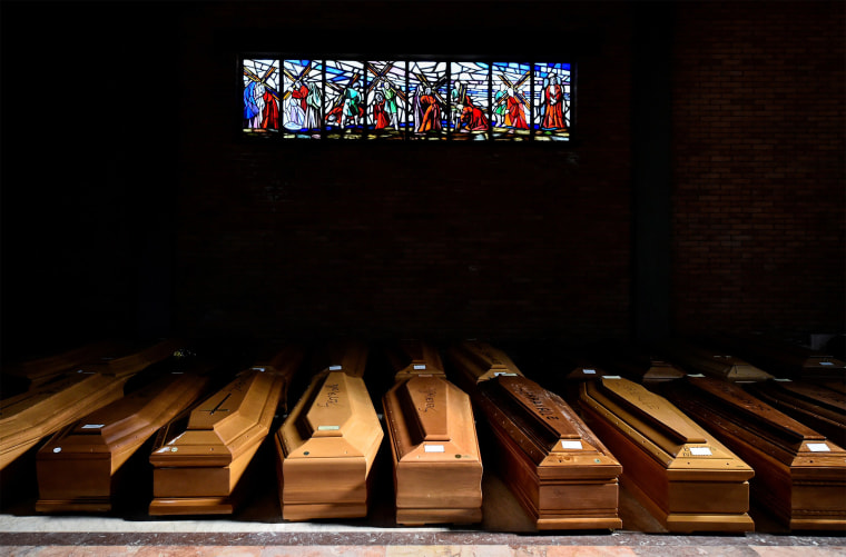Image: Coffins of people who have died from Covid-19 are seen in the church of the Serravalle Scrivia cemetery