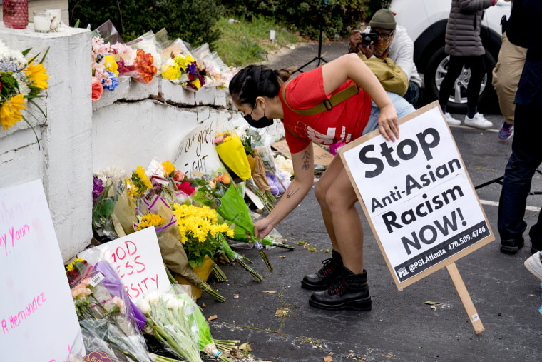 Image: Activists drop flowers during a demonstration against violence against women and Asians following Tuesday night's shooting on March 18, 2021 in Atlanta.