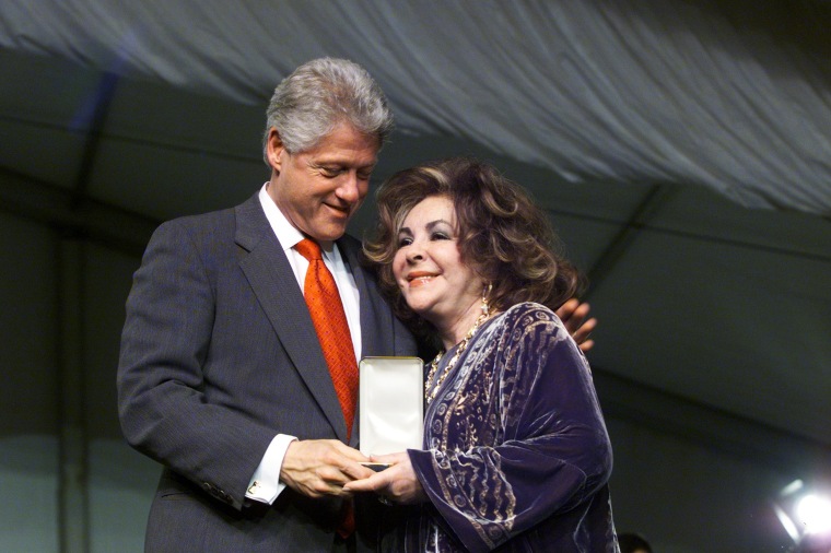 President Bill Clinton smiles at actress Elizabeth Taylor as