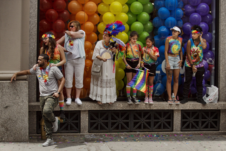 Image: People watch as revelers march during the annual Pride Parade in New York