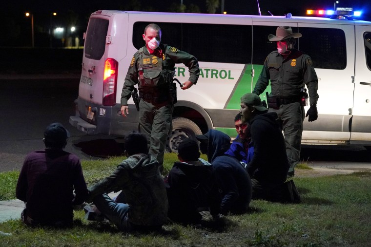 U.S. Customs and Border Protection agents take people into custody people near the border with Mexico on March 20, 2021, in Hidalgo, Texas.