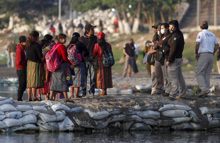 Image: Mexican immigration agents review the IDs of Guatemalan travelers at an access point to the Suchiate River, on the border between Guatemala and Mexico, near Ciudad Hidalgo, Mexico on March 21, 2021.