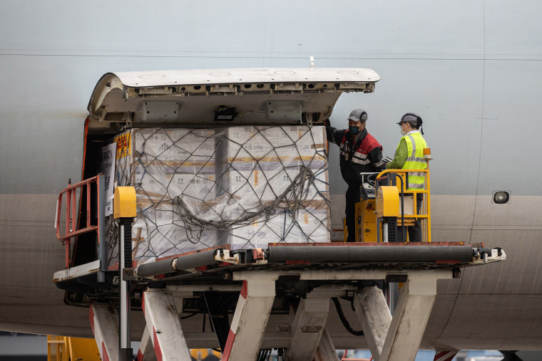 Image: A container carrying Pfizer-BioNTech Covid-19vaccines is unloaded from a Cathay Pacific cargo plane at Hong Kong International Airport in Hong Kong,