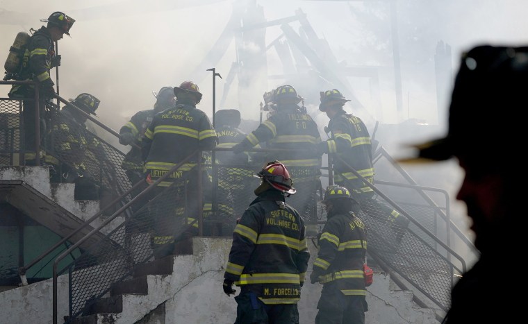 Image: Firefighters work the scenes of a fire that burned down the Evergreen Court Home for Adults