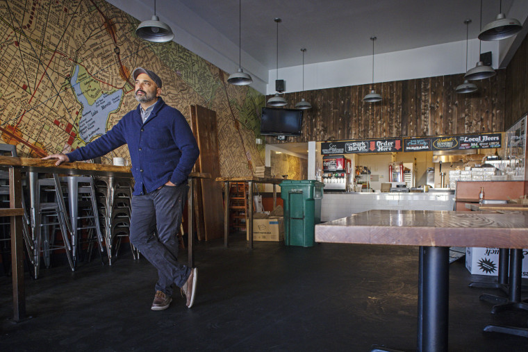 IMAGE: Tipu Barber, owner of Park Burger, stands in his empty dinning room.