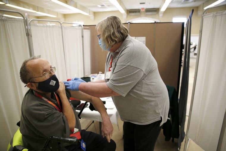 A RN volunteering with the Medical Reserve Corps administers a dose of the Moderna Covid-19 vaccine at the Lowell Senior Center in Lowell, Mass., on Feb. 25, 2021.