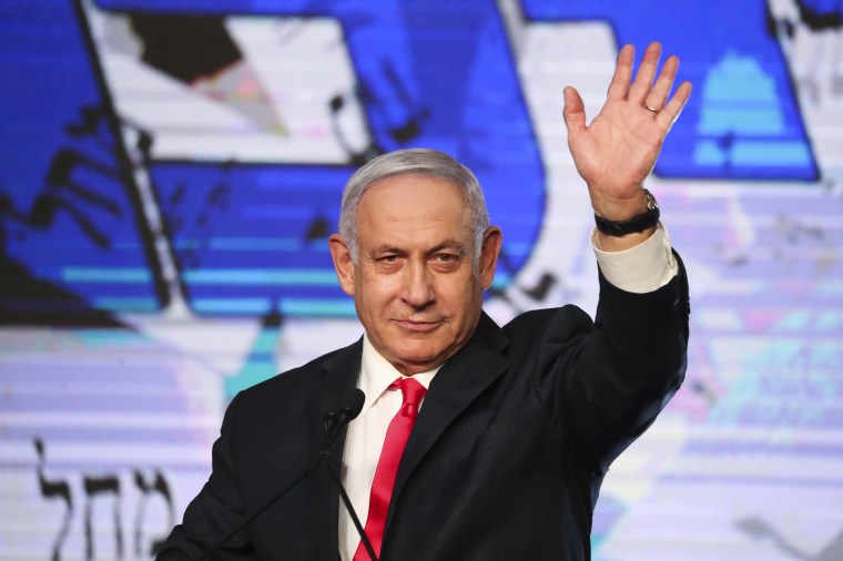 Image: Israeli Prime Minister Benjamin Netanyahu waves to his supporters after the first exit poll results for the Israeli parliamentary elections at his Likud party's headquarters in Jerusalem