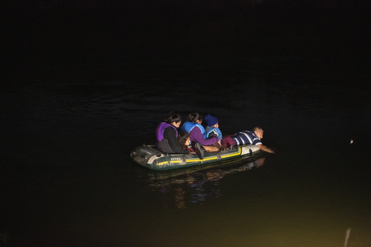 Image: A smuggler takes migrants, mostly from Central American countries, on a small inflatable raft towards U.S. soil in Roma, Texas on March 24, 2021. A surge of migrants on the Southwest border has the Biden administration on the defensive.