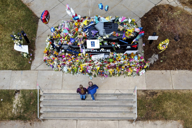 Image: People look at flowers surrounding a police vehicle as a memorial for slain Boulder Police officer Eric Talley at the Boulder Police Department on March 25, 2021 in Boulder, Colo.