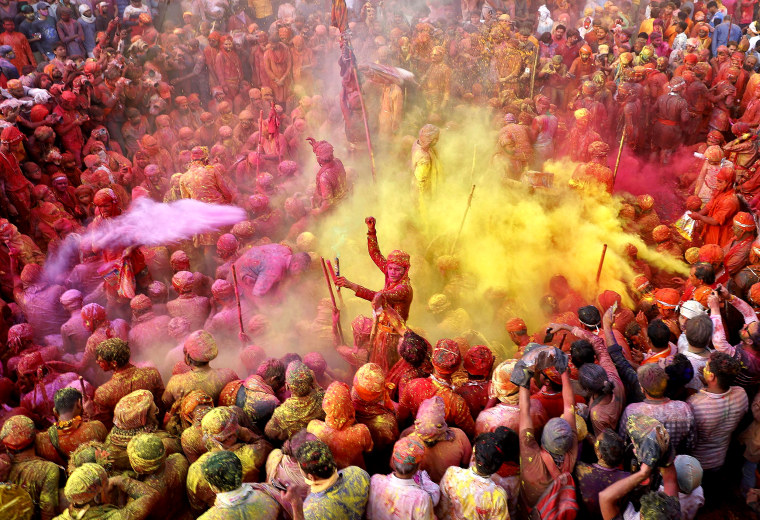Image: Men daubed in colors throw colored powder at each other during Lathmar Holi celebrations, in the town of Nandgaon, in the northern state of Uttar Pradesh, India, on March 24, 2021.