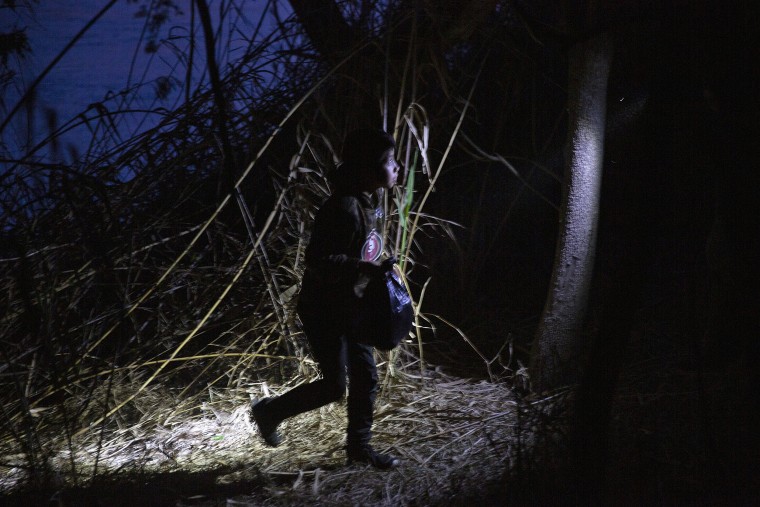Image: A young child walks alone through the brush after being smuggled across the Rio Grande river in Roma, Texas on March 24, 2021.