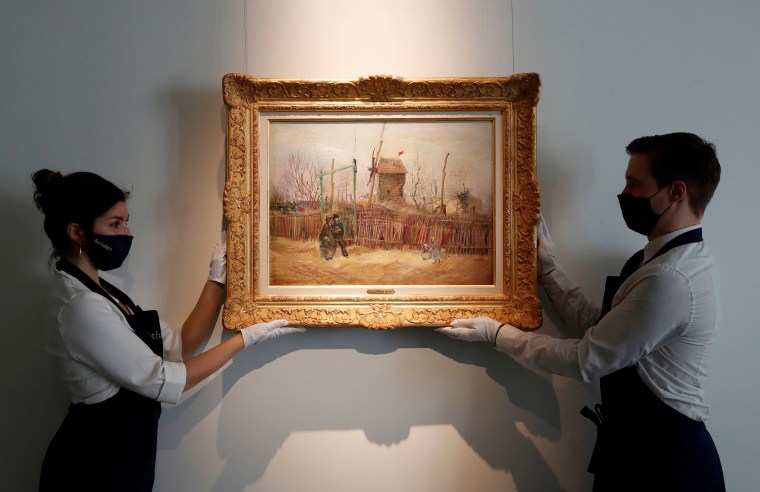 Image: Sotheby's Paris employees pose with the 1887 painting of a Paris street scene \"Scene de rue a Montmartre\" by Dutch painter Vincent Van Gogh
