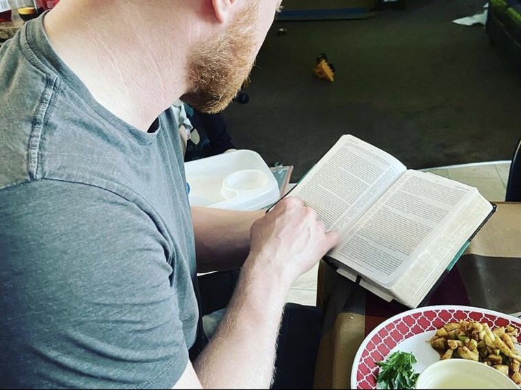 Photo of man reading a book (the Bible)