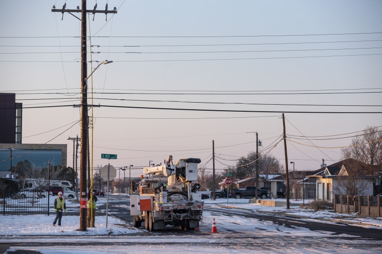 Image: An Oncor Electric Delivery crew works on restoring power to a neighborhood following the winter storm that passed through Texas Feb. 18, 2021, in Odessa, Texas.