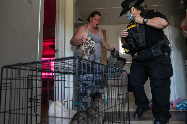 Image: Maricopa County constable Darlene Martinez helps a single mother of two cage her pets after receiving an eviction order for non-payment of rent