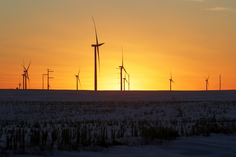 A wind farm shares space with corn fields in Latimer, Iowa, on Feb. 2, 2020.