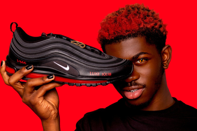 Image: Lil Nas X holds a pair of Satan Shoes created with the company MSCHF.