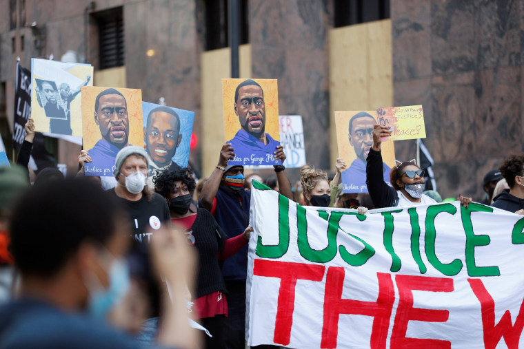 Image: Protesters march for George Floyd on the day of opening statements for the trial of Chauvin in Minneapolis