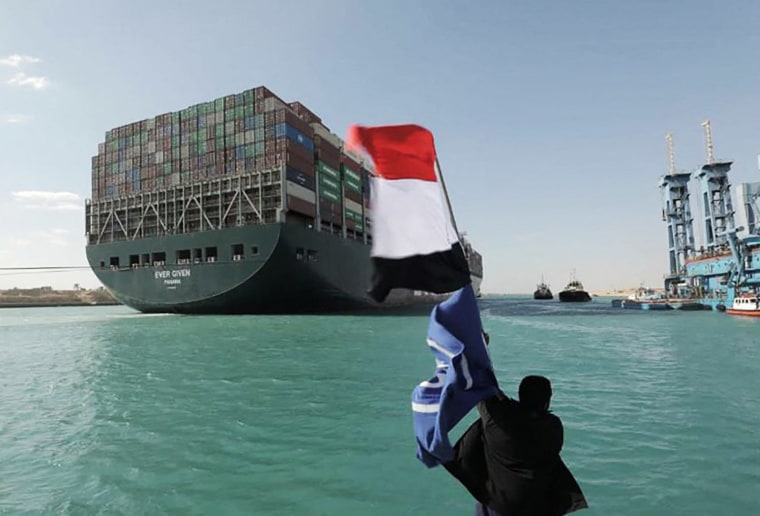 A picture released by Egypt's Suez Canal Authority on March 29, 2021, shows a man waving the Egyptian flag as the Ever Given container ship is dislodged.