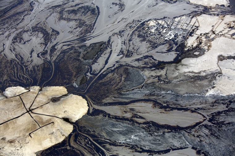 Image: Oil flows into a tailings pond at a tar sands operations in Alberta, Canada in 2014.