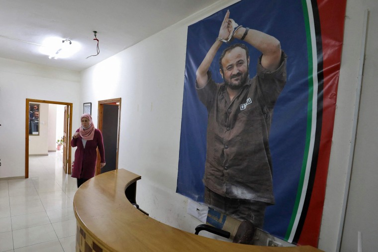 Image: A member of the staff walks near a picture of Palestinian Marwan Barghouti, in Israeli custody for nearly two decades after being convicted over multiple killings during the second intifada, at an office in support of Barghouti in the West Bank cit