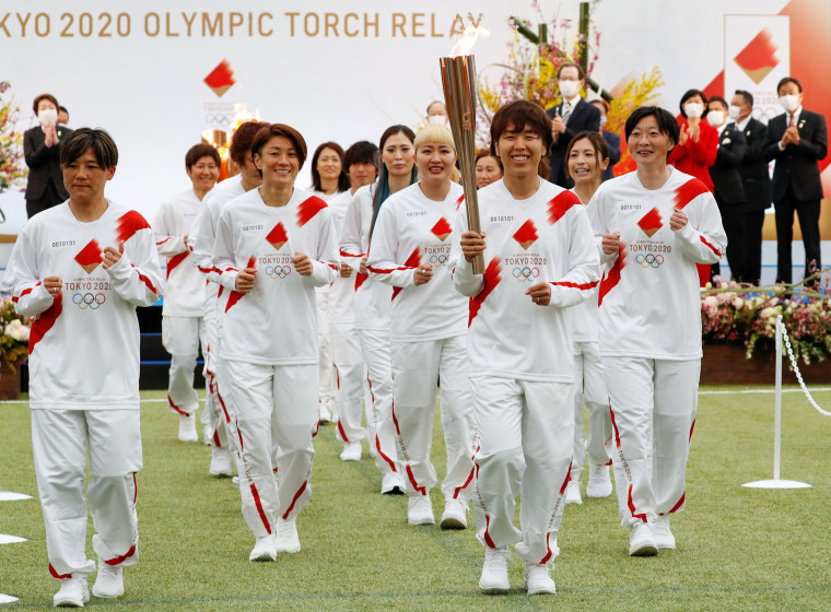 Image: Members Japan's women's national soccer team lead the torch relay during the Tokyo 2020 Olympic Torch Relay Grand Start in Naraha
