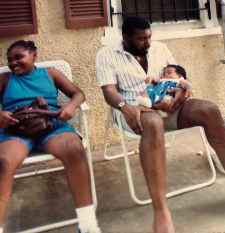 Semo holding his baby niece next to one of his daughters.