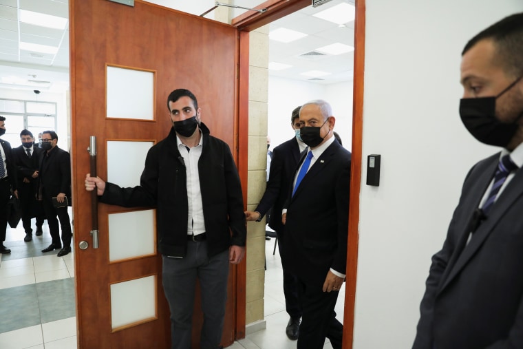 Image: Israeli Prime Minister Benjamin Netanyahu, wearing a face mask, leaves the courtroom during a hearing as his corruption trial resumes, at Jerusalem's District Court