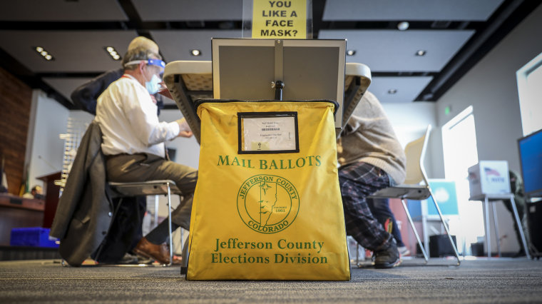 A mail-in ballot collection box sits on the floor at Edgewater City Hall on Nov. 3, 2020 in Edgewater, Colo.