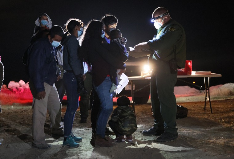 Image: A United States Border Patrol agent processes migrants after they arrived illegally from Mexico on March 29, 2021 in Roma, Texas.