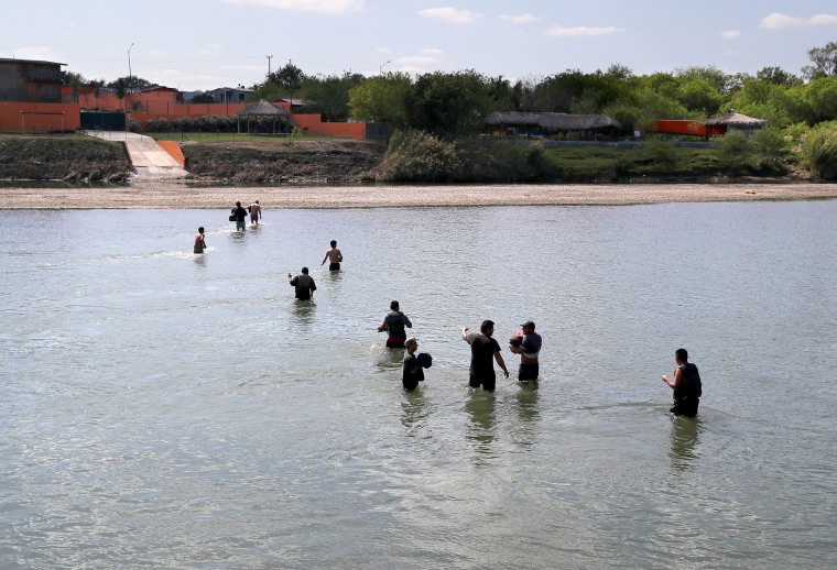 A group of undocumented immigrants wade across the Rio Grande at the U.S.-Mexico border on March 14, 2017 in Roma, Texas.