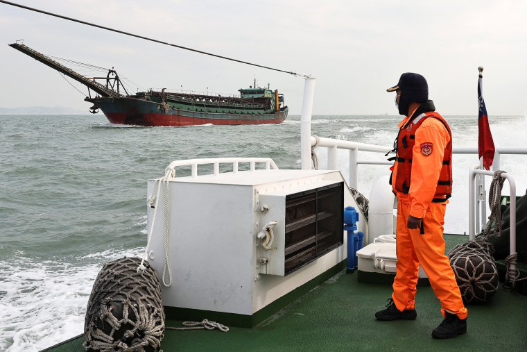 Image: A Taiwanese coast guard looks at a sand-dredging ship with a Chinese flag in the waters off the Taiwan-controlled Matsu islands, on Jan. 28, 2021.