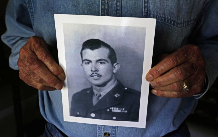 Ray Lambert, a 1st Infantry Division combat veteran of the D-Day invasion, holds a copy of an old photograph of himself in uniform at his home in Seven Lakes, N.C., on April 17, 2014.