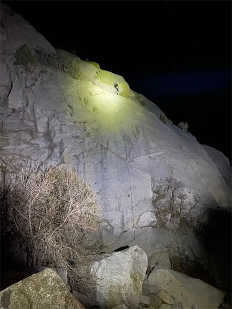 A rescue team with the Salt Lake County Sheriff's Search and Rescue shine a high-powered light to help climbers descend safely in Little Cottonwood Canyon, Utah, on April 9, 2021.