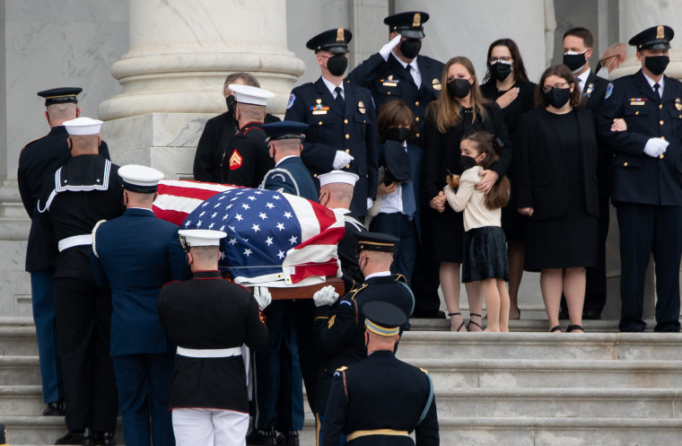 Logan and Abigail Evans stand with their mother and grandmother while William Evans' casket is carried into the Capitol Rotunda.