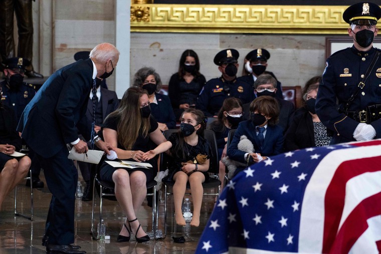 President Joe Biden picks up a toy for Abigail Evans. 