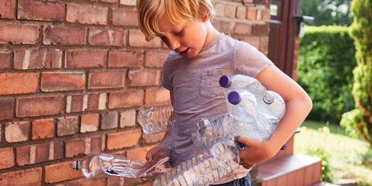 Child recycles plastic water bottles.
