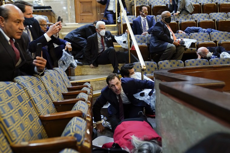People shelter in the House gallery as rioters try to break into the chamber.