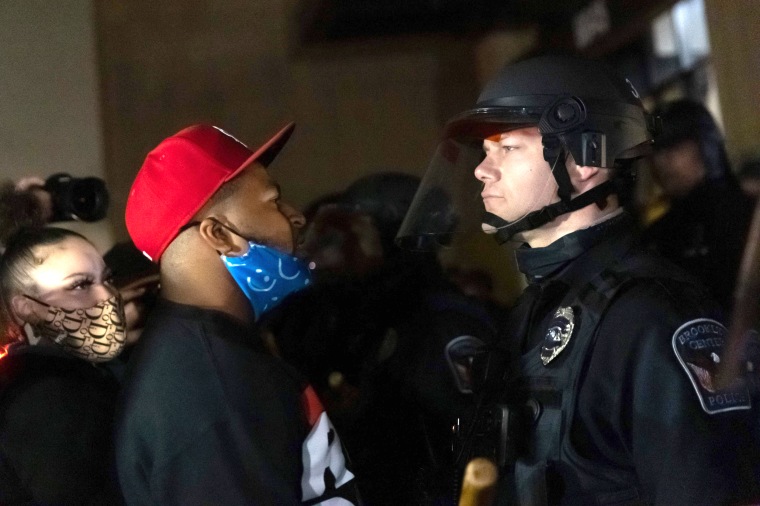 Image: Protesters confront a line of police officers