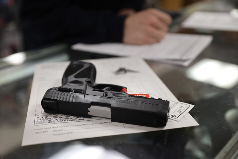 Image: A customer purchases a gun at Freddie Bear Sports on April 8, 2021 in Tinley Park, Illinois.