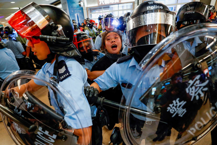 Image: Riot police detain a woman as protesters gather at Sha Tin Mass Transit Railway station in on Sept. 25, 2019.