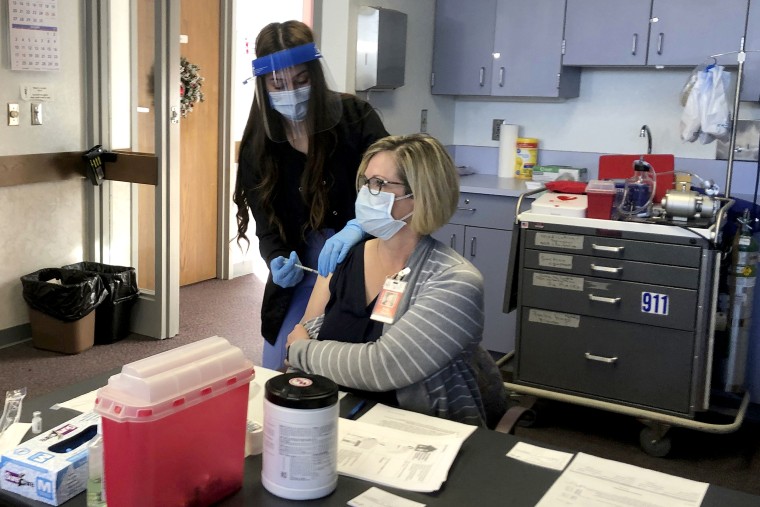 A Cheyenne-Laramie County Health Department nurse administers Wyoming's first shot of the Pfizer-BioNTech Covid-19 vaccine to Terry Thayn, who is also a nurse for the department, on Dec. 15, 2020, in Cheyenne, Wyo.
